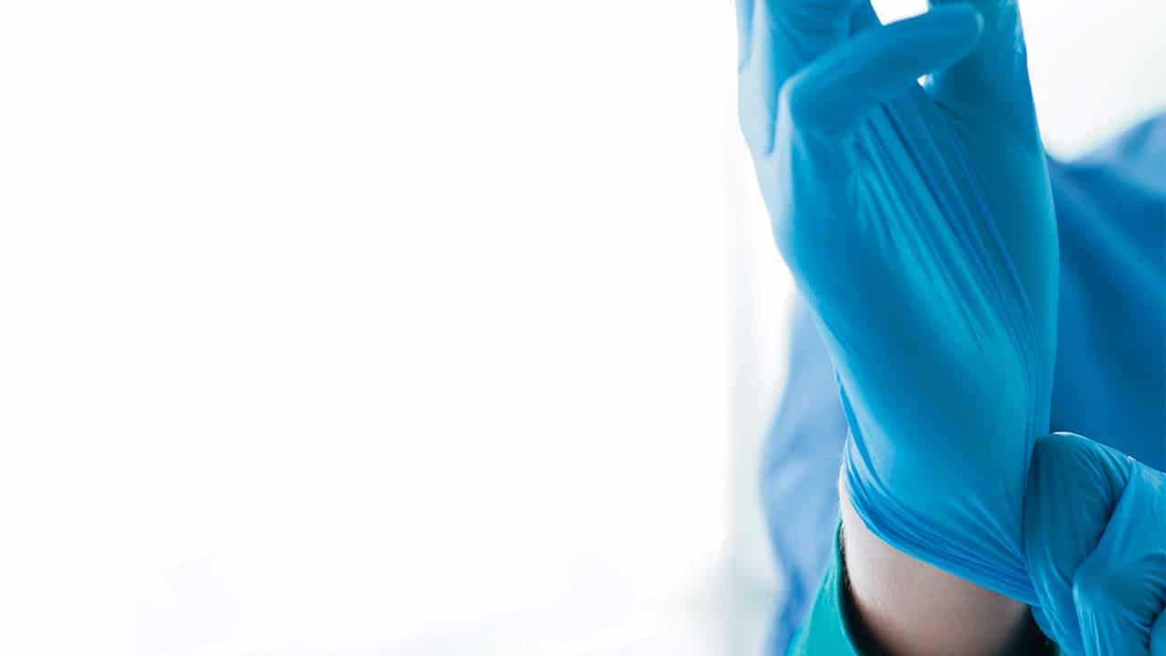 Clinician putting on a glove