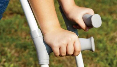 close up of hands holding crutches