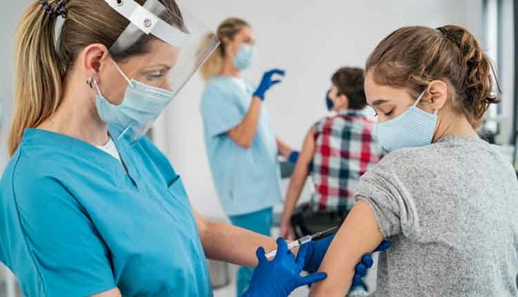Doctor vaccinating girl. Injecting COVID-19 vaccine into patient's arm