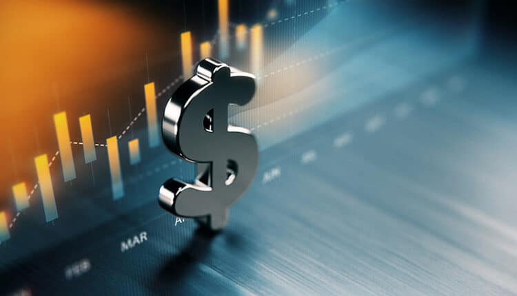 American Dollar Symbol Standing On Wood Surface In Front Of A Graph