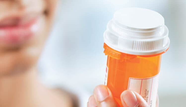 woman looking at medication bottle