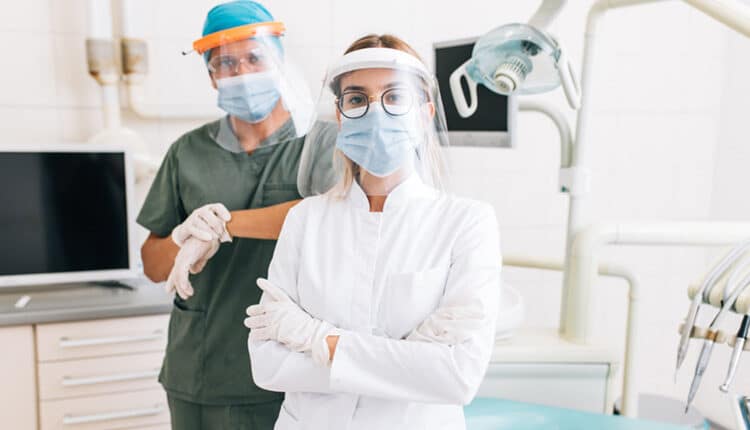 Portrait of dentist with young female assistant
