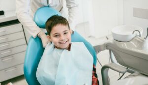 Young Smiling Boy Getting Prepared for the Regular Dental Check Up in Clinic