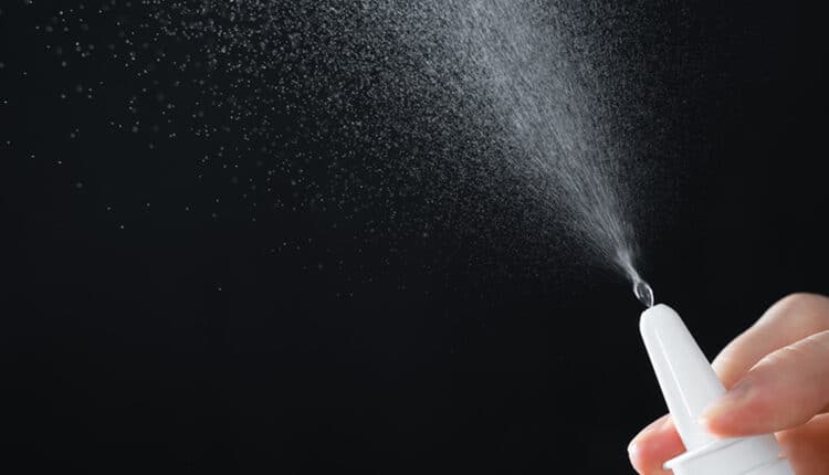 man's hand with a bottle of medication. Treatment colds via a nasal spray