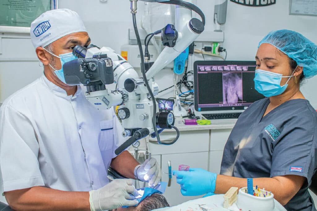 FIGURE 4. Note the operator’s neutral posture when utilizing the surgical microscope, which is further aided by use of a four-handed technique with the dental assistant.